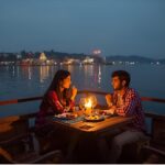 Couple having private candlelit dinner on houseboat deck with Dal Lake in background
