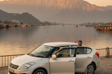 Swift Dzire cab service in Kashmir 2026 featuring clean white Swift Dzire sedan with professional driver at Dal Lake Srinagar