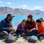 Cheapest Ladakh tour packages for family 2026 - happy family of four at Pangong Lake with camping tents, child discounts 25-35% off, prices from ₹10,000-55,000 for 2-7 day family tours including Leh, Nubra, Pangong