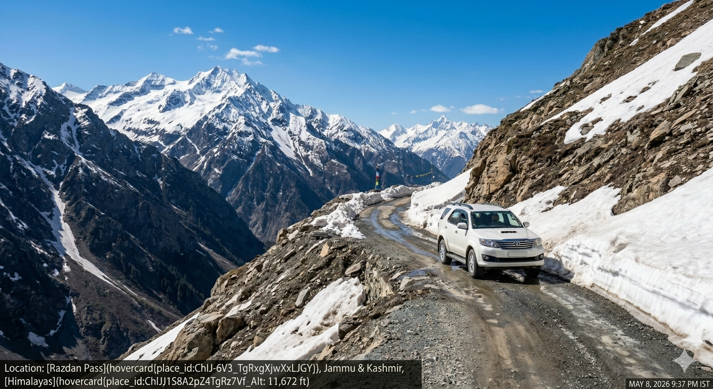 A 4x4 SUV winding through the curves of Razdan Pass with snow-capped Himalayan peaks in the background