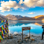 Best places to visit in Leh Ladakh 2026 - Pangong Tso lake with snow-capped Himalayan mountains and travelers capturing the moment