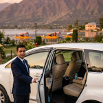 Kashmir VIP taxi service 2026 - professional chauffeur in uniform with white Innova Crysta at Nishat Garden overlooking Dal Lake for premium luxury travel