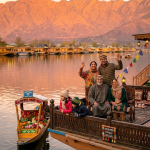 Kashmir family package with houseboat 2026 - multi-generational Indian family on traditional Kashmiri houseboat deck at Dal Lake golden hour