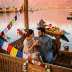 Kashmir honeymoon package price 2026 - newlywed couple sharing Kahwa on houseboat deck at Dal Lake golden hour
