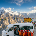 Tempo traveller for 10 persons Leh Ladakh 2026 - Force Urbania 12 seater with group of 10 travelers at Khardung La pass 18380 feet highest motorable road
