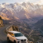 Luxury SUV rental Srinagar price per day 2026 - Toyota Fortuner on mountain road with Himalayas