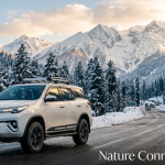 Toyota Fortuner 4x4 rental in Kashmir with driver parked on snowy Gulmarg highway with Himalayan mountains